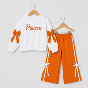 White and orange tracksuit for girls with "Princess" design, featuring bows on sleeves and pants. Cozy and stylish.