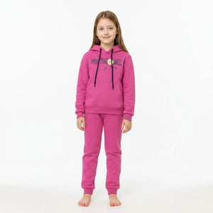 Young girl wearing a pink 'Awesome' hoodie with a flower graphic in a living room.