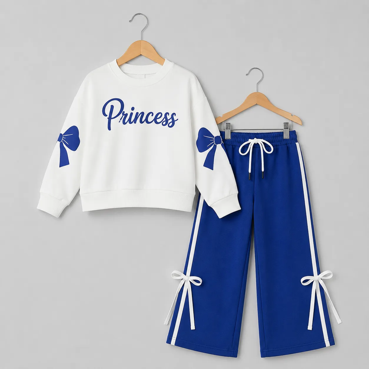 White and blue girls' tracksuit featuring "Princess" text and bow details on the sweatshirt and pants.