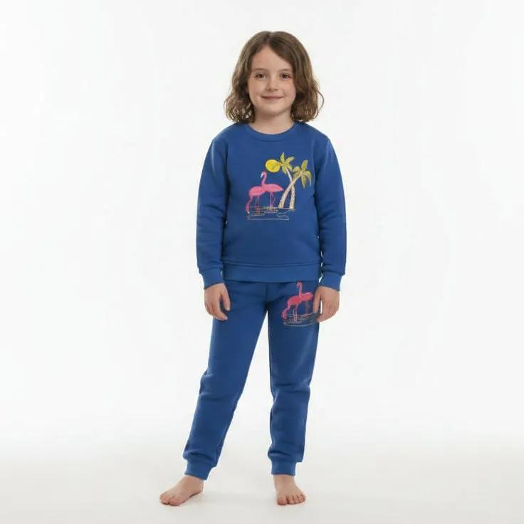 Child wearing a blue sweatshirt with flamingo design in a living room setting