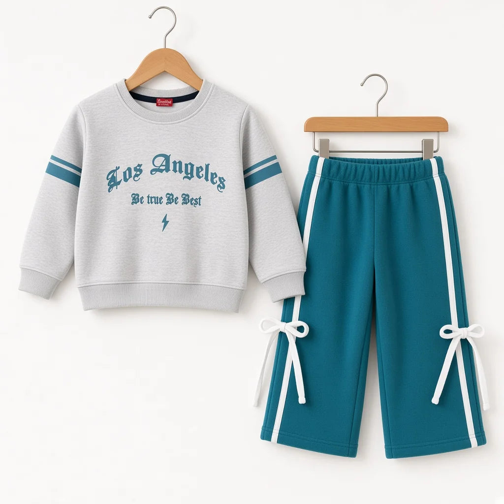 A children's two-piece tracksuit set hanging on wooden hangers against a plain white background. The set includes a light gray sweatshirt with teal lettering and sleeve stripes, and teal pants with white side stripes and white drawstring ties at the hems.